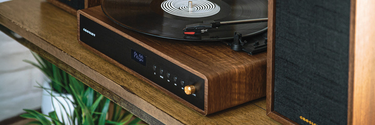 Crosley speaker displayed on a wooden tray beside white flowers