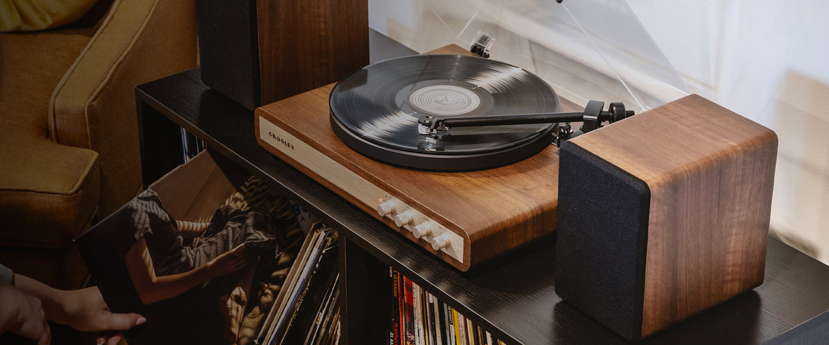 Crosley C65 turntable playing a vinyl record on a wooden cabinet