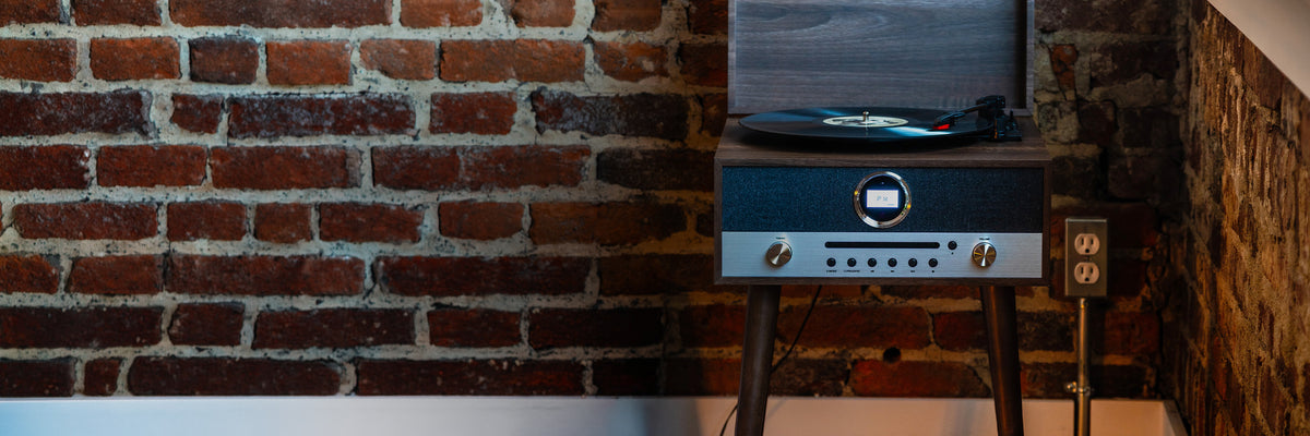 A woman smiling beside a Crosley record player